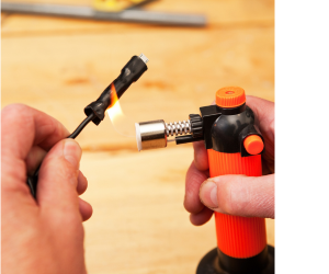 мужчина поджигает термоусадочную трубку