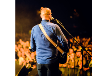 чоловік виступає на сцені з мікрофоном з кабелем чоловік виступає на сцені з мікрофоном з кабелем