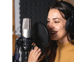 дівчина використовує мікрофон з кабелем в студії дівчина використовує мікрофон з кабелем в студії